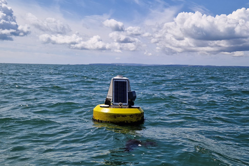 Beach buoy deployed off Hayling Island A bright yellow data buoy with solar panel mounted floating in the sea